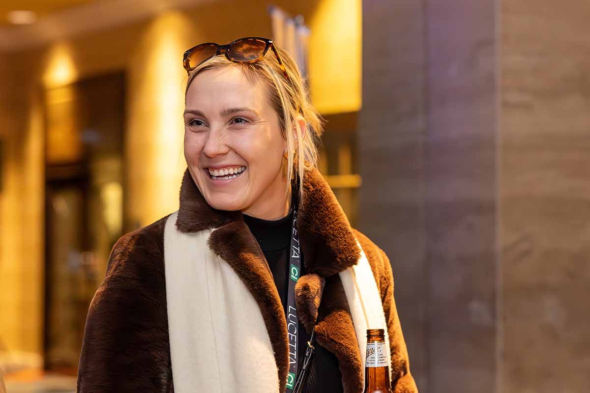 blonde woman with sunglasses laughing as she looks to her right